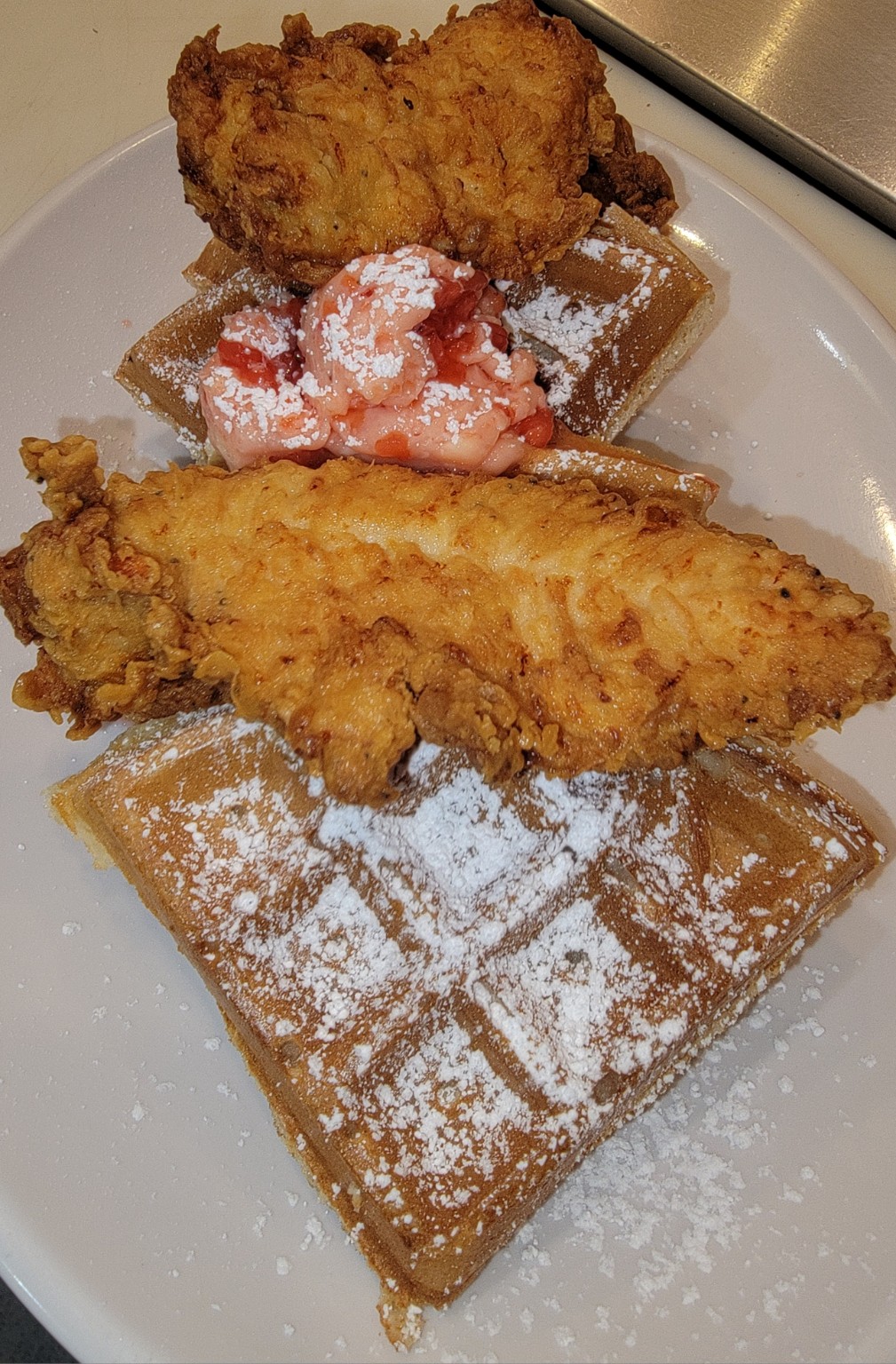 Chicken and waffles with strawberries at The 80's Cafe
